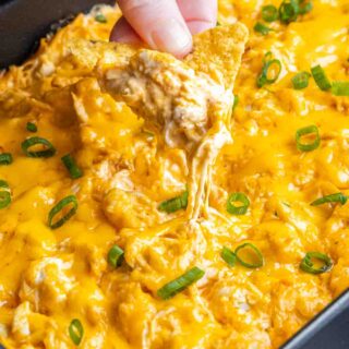 dipping a chip in Oven Buffalo Chicken Dip