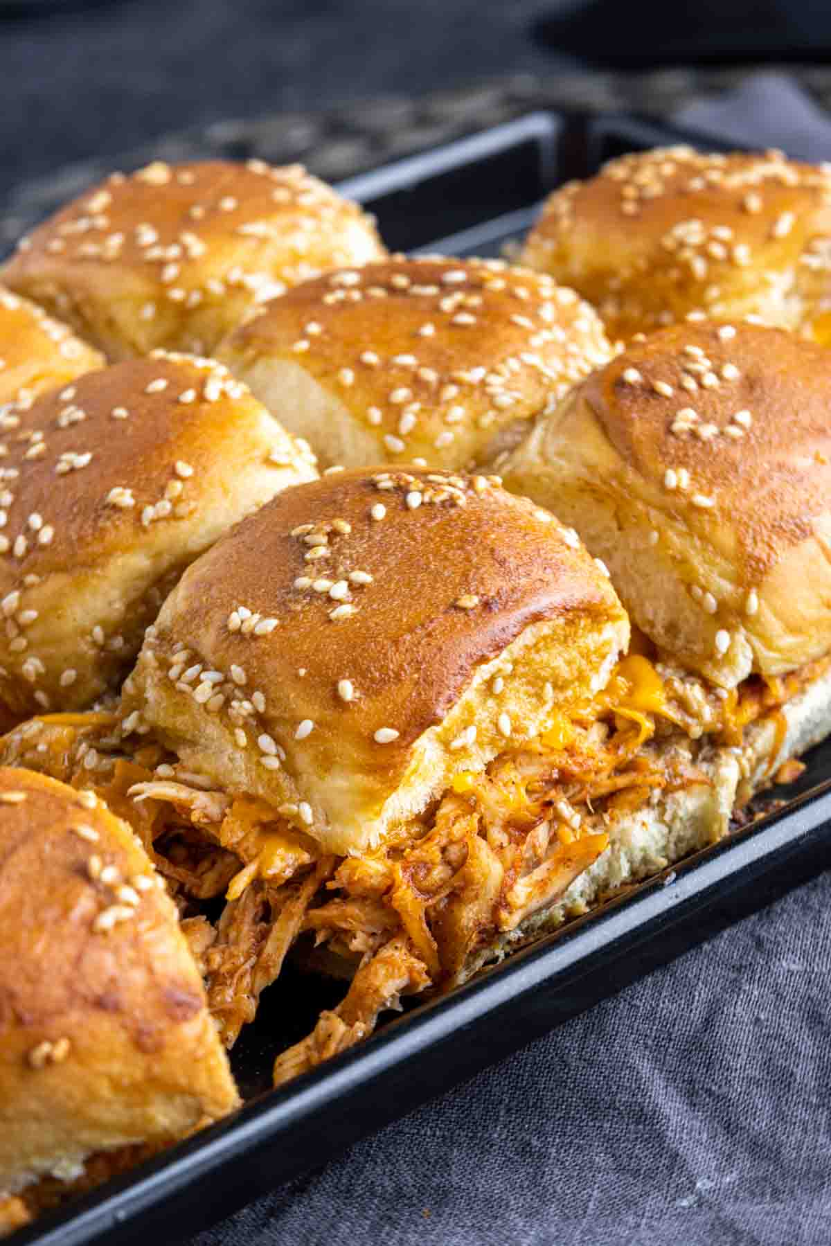 close up of BBQ chicken sliders on a baking sheet