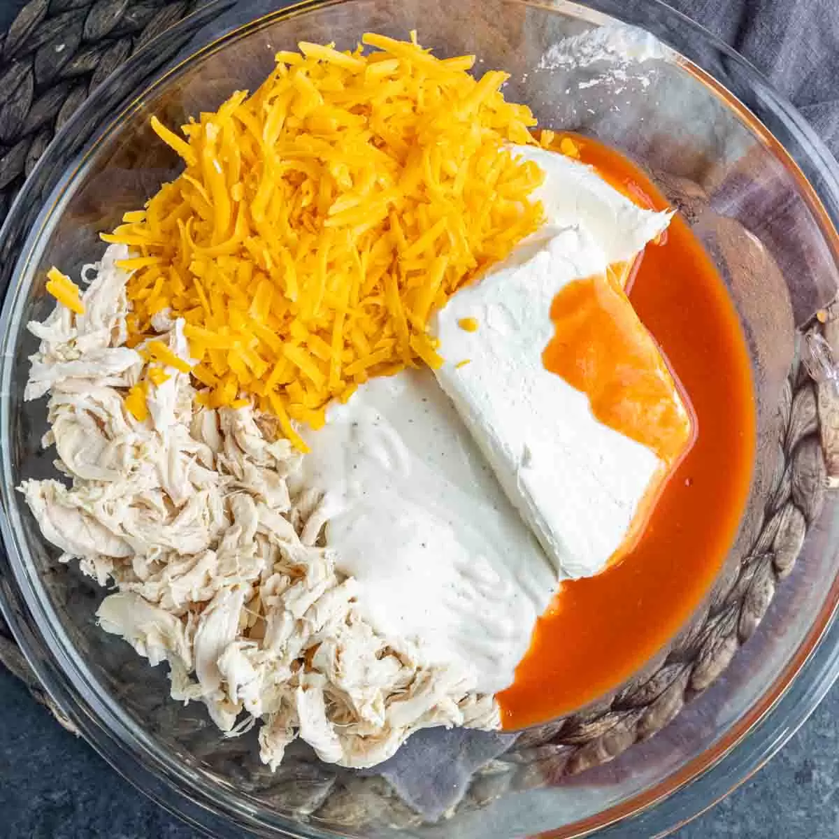 Oven Buffalo Chicken Dip ingredients in a glass bowl