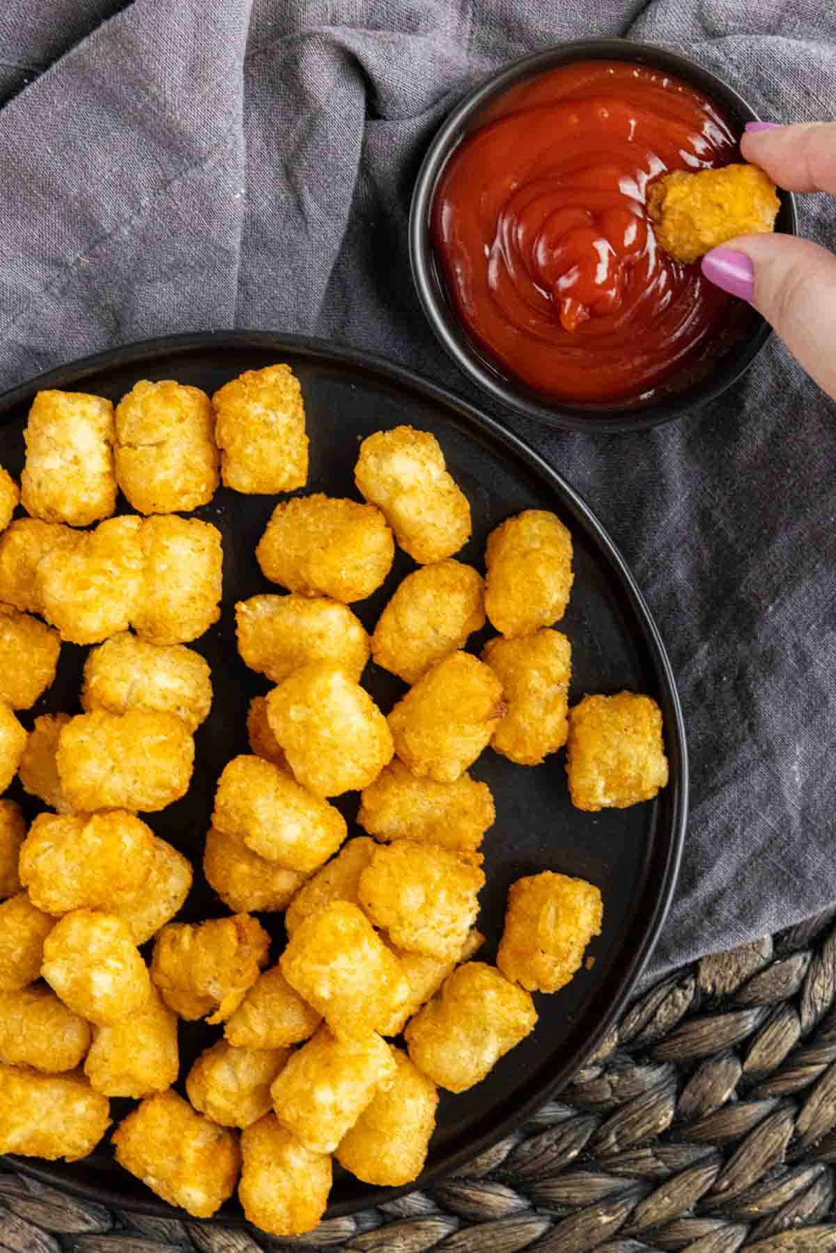 dipping Air Fryer Tater Tots in ketchup