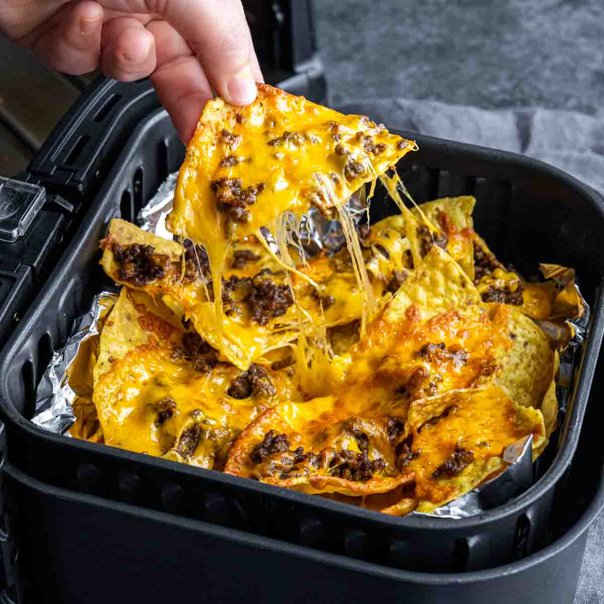 pulling Air Fryer Nachos out of the air fryer