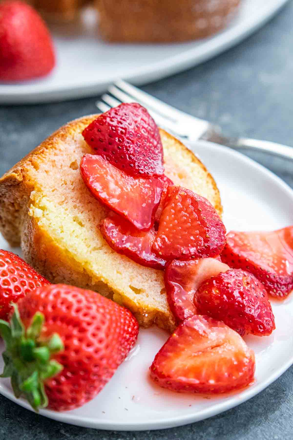 Sour Cream Pound Cake slice on a plate with strawberries