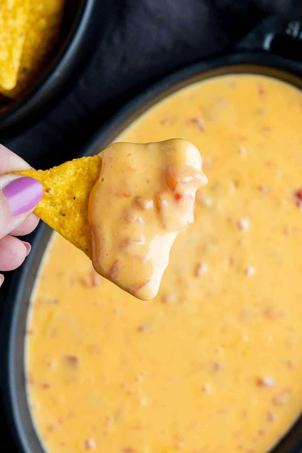 holding a chip dipped in Rotel Dip