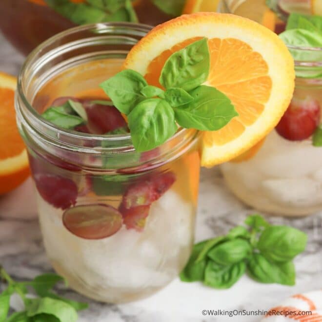 Mason jar filled with sliced grapes and basil leaves