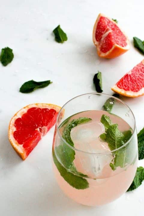 glass of pink grapefruit and mint infused water with ice.