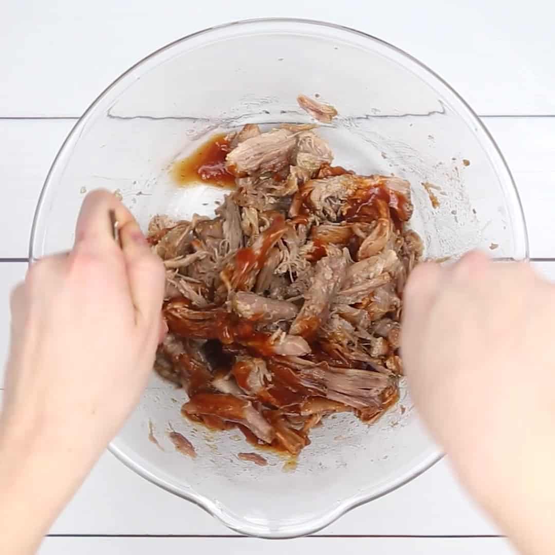 Instant Pot Pulled Pork in a glass bowl with BBQ sauce