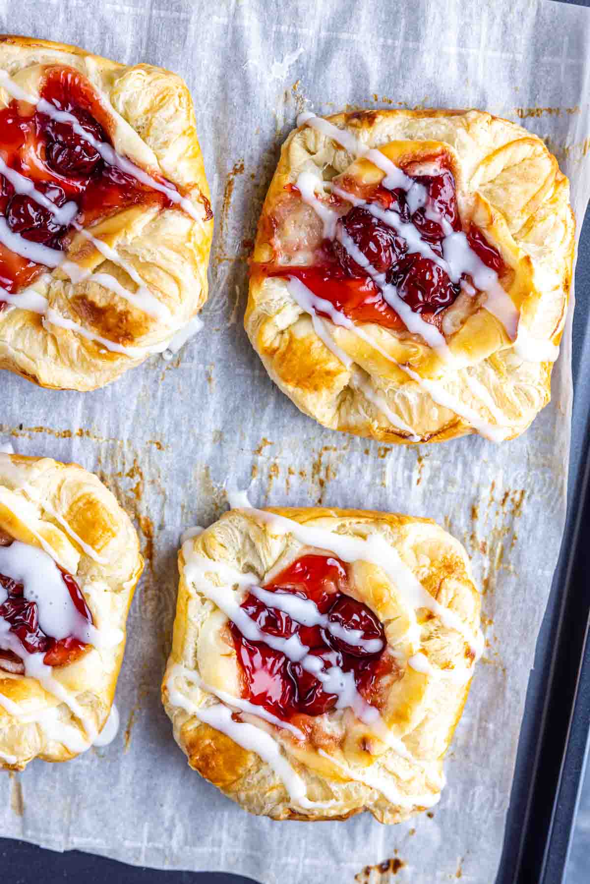 Cherry Danish on parchment paper with glaze