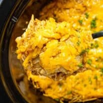 scooping Crock Pot Chicken Enchiladas out of the slow cooker