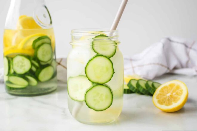 Mason jar filled with water and sliced of cucumber