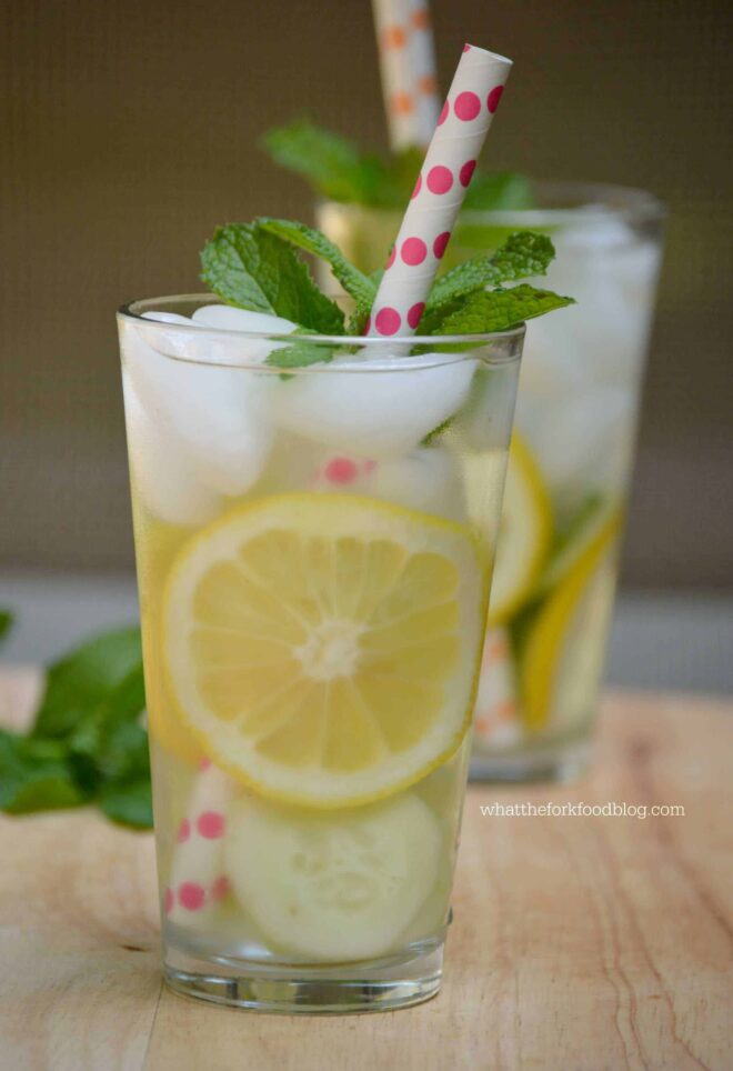 Glass of water with ice and fresh slices of lemon and mint