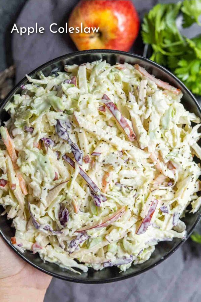 pinterest image of holding a bowl of Apple coleslaw