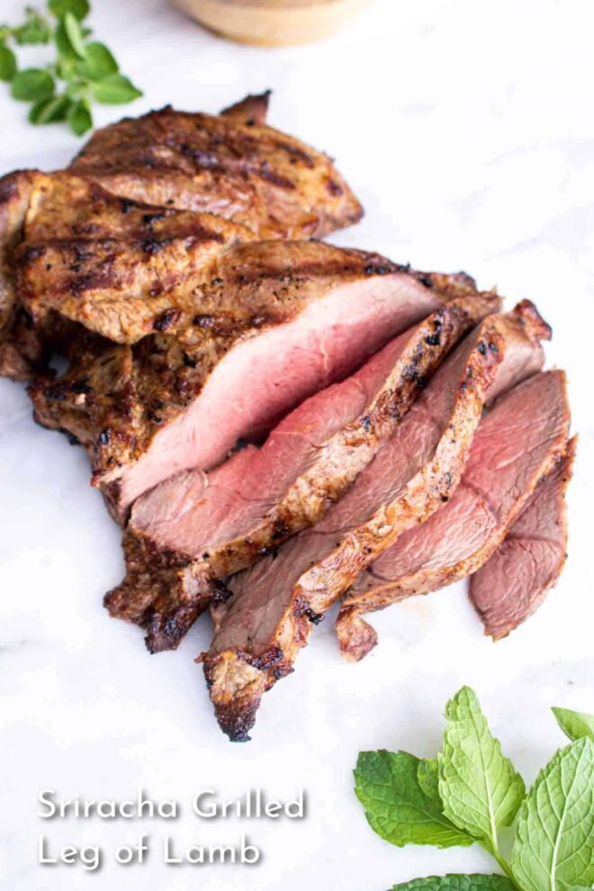 Sriracha Grilled Leg of Lamb on white board with herbs