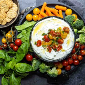 Whipped Ricotta and Tomato Dip in a bowl on a vegetable platter