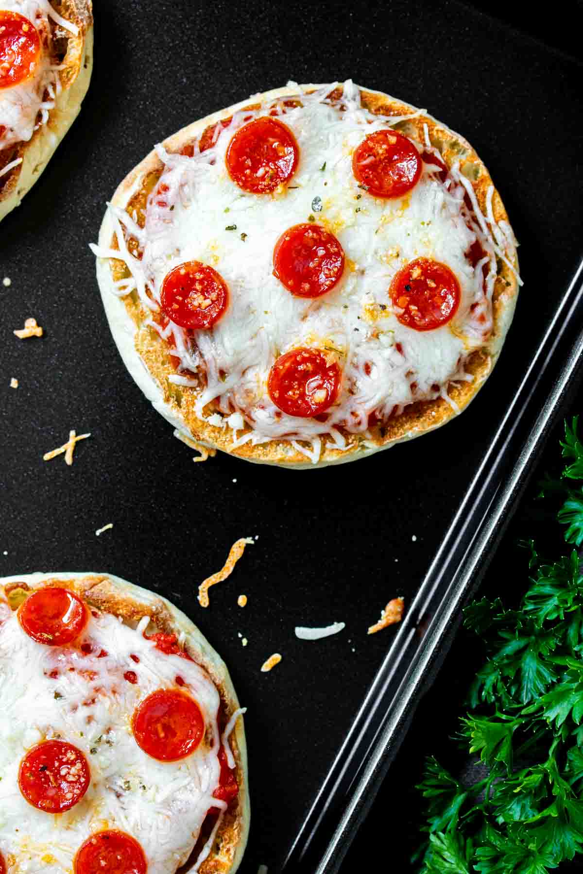 english muffin pizzas on a baking sheet.