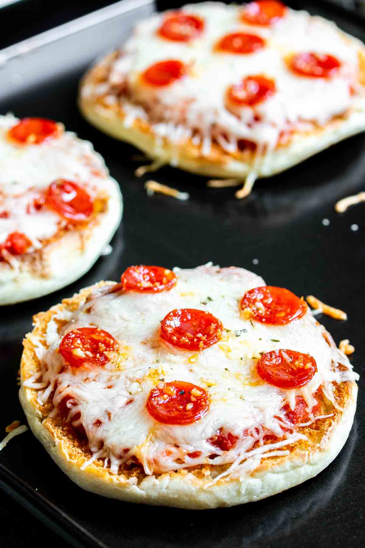 english muffin pizzas on a baking sheet.