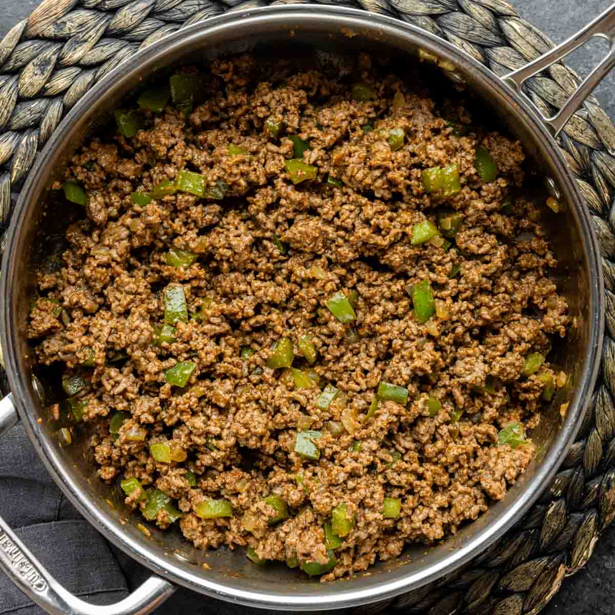 A skillet filled with ground beef and green peppers for John Wayne Casserole