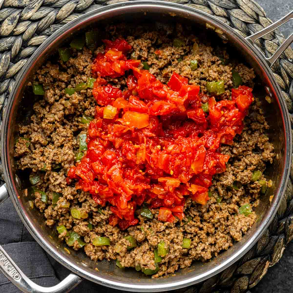A skillet filled with meat and tomato sauce for John Wayne Casserole filling