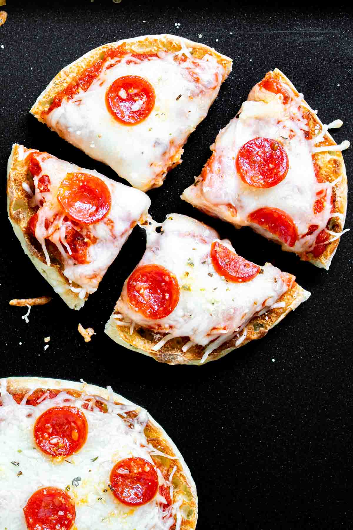 A english muffin pizzas with pepperoni on it.