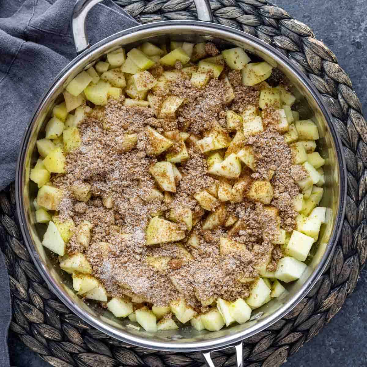 Apples in a pan with cinnamon and sugar for apple pie filling