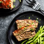 Keto Meatloaf on a plate with green beans and a fork.