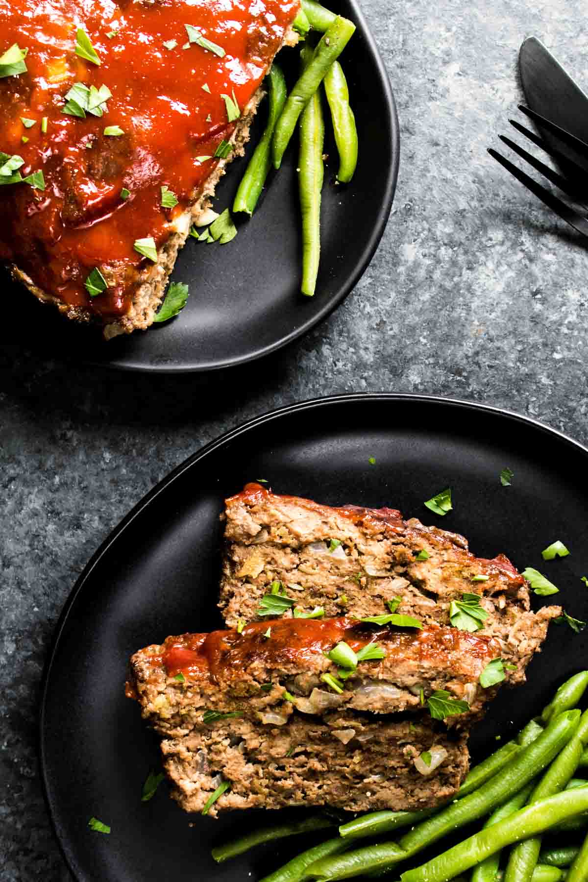 A plate of keto meatloaf with green beans on it.
