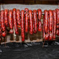 A bunch of Portuguese sausage hanging on a rack drying