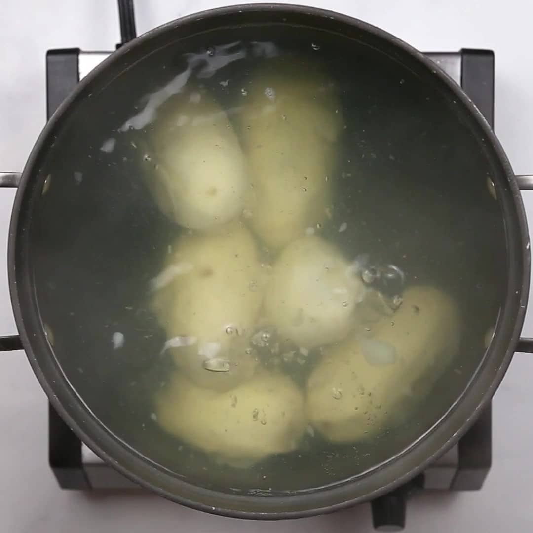 Boiling potatoes in a pot on top of a stove for Duchess Potatoes