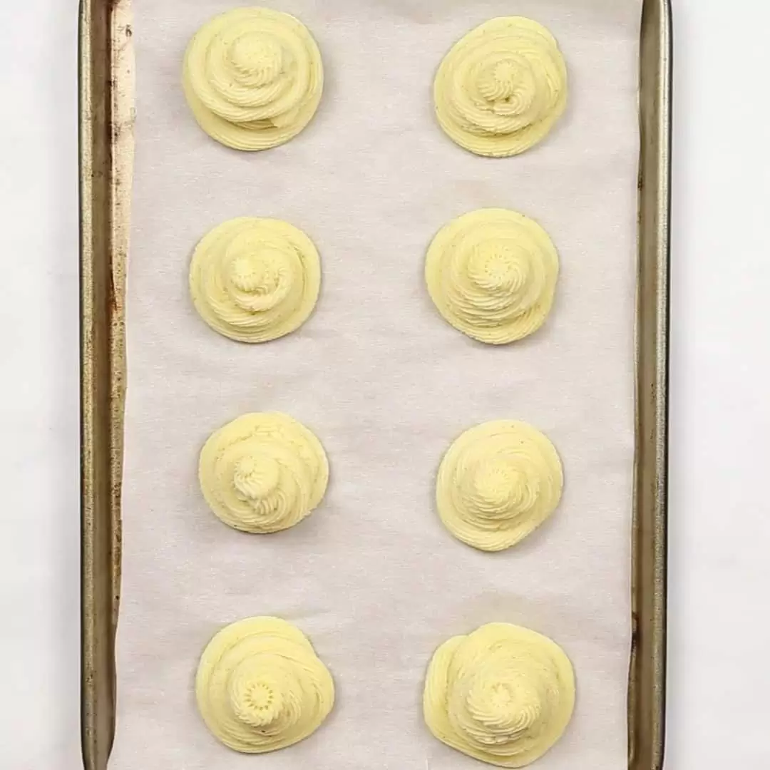 A baking sheet with a tray of fDuchess Potatoes
