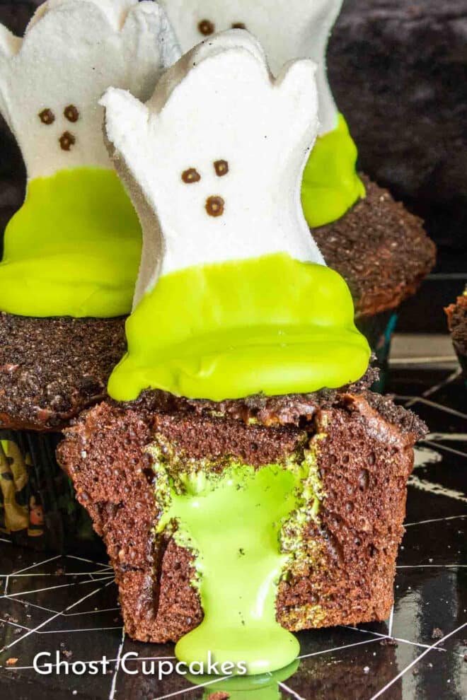 Ghost cupcakes with green icing on top.