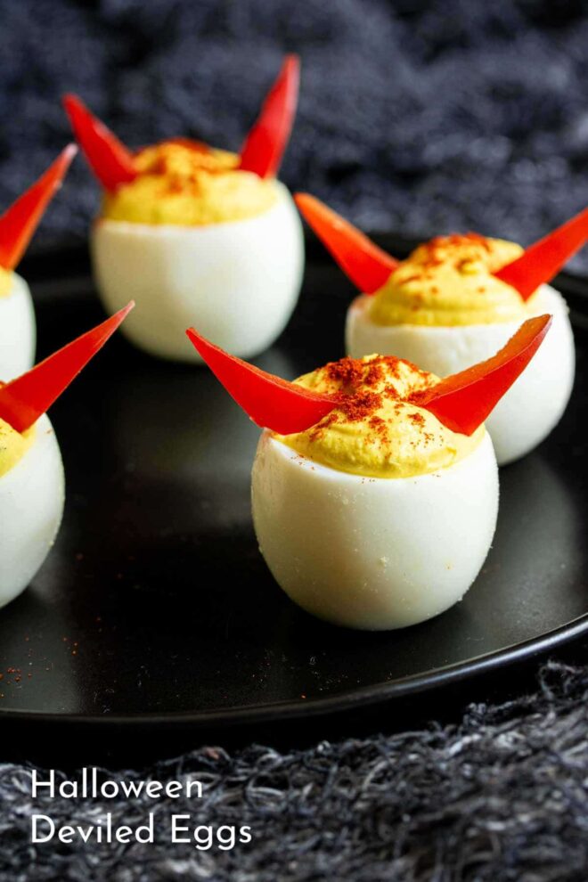 pinterest picture of Halloween deviled eggs on a black plate.