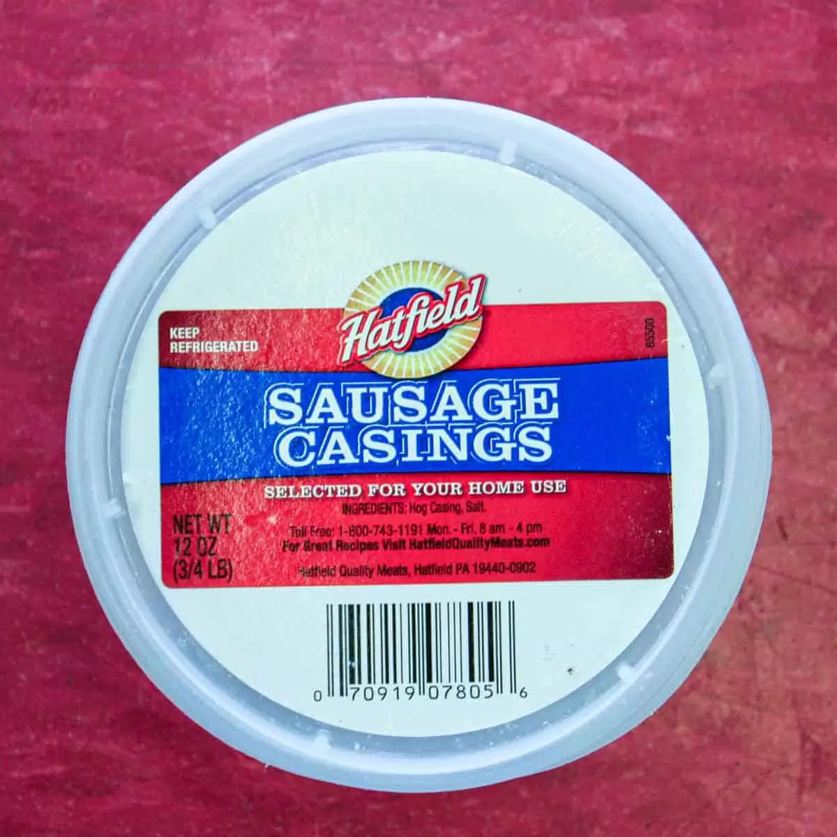A container of sausage casings on a red surface to make Portuguese sausage