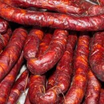 A pile of red sausages on a table.