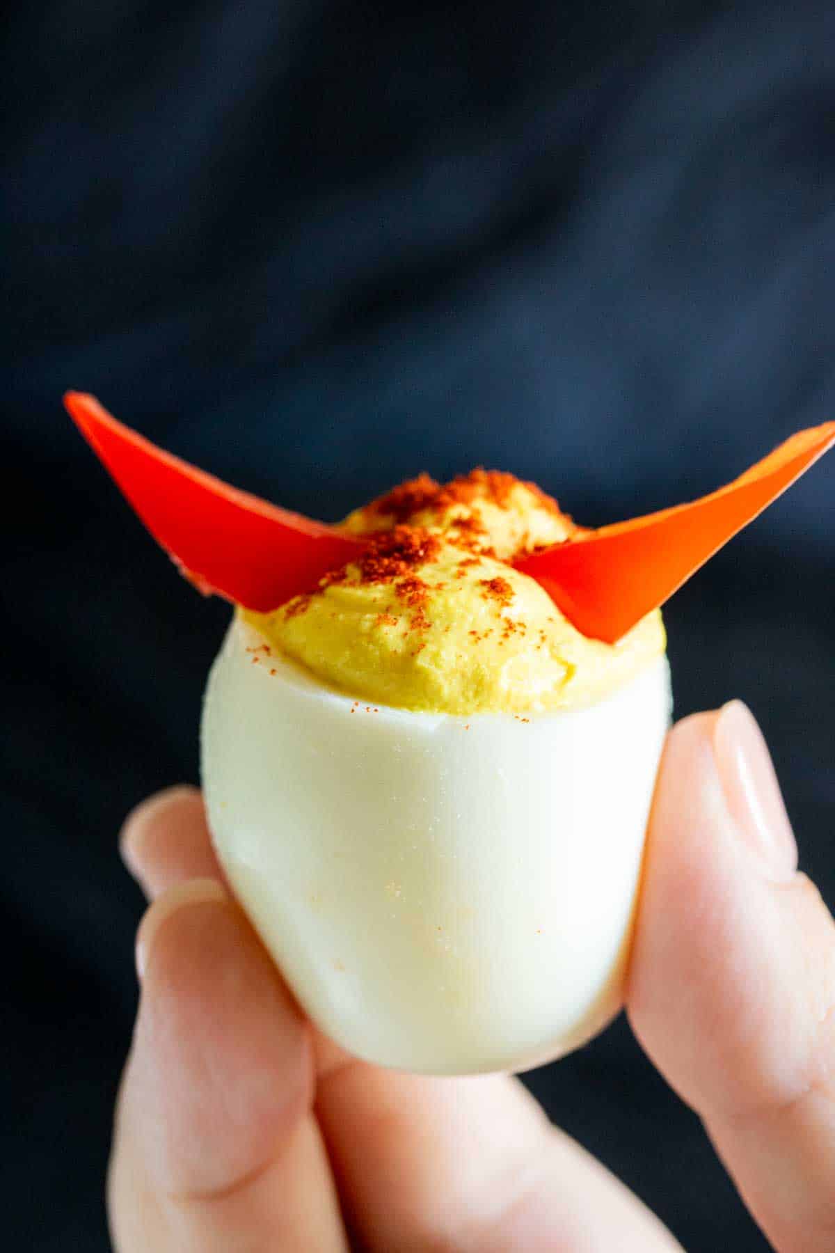 A person holding up Halloween Deviled Eggs