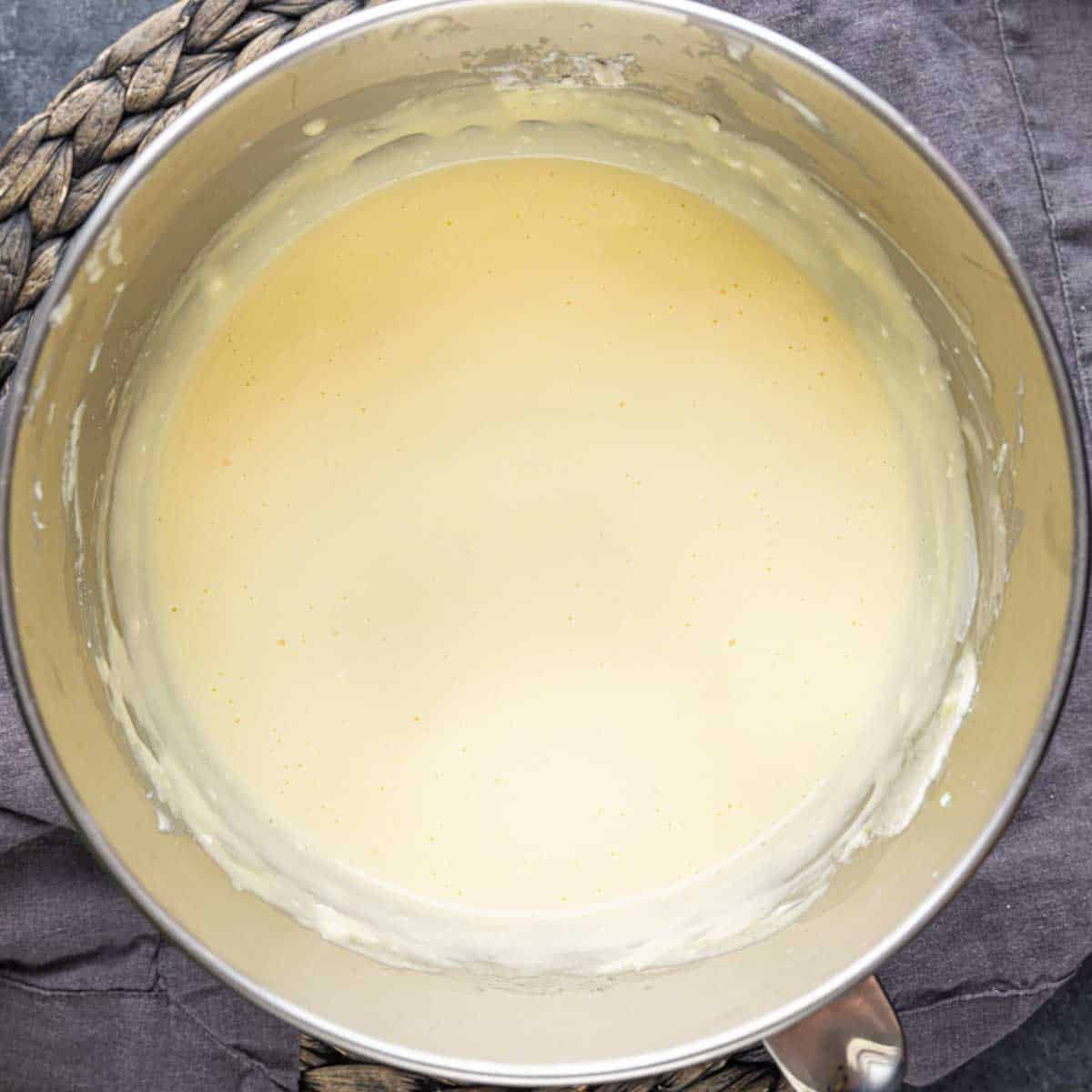 A metal mixing bowl with Mini cheesecake batter