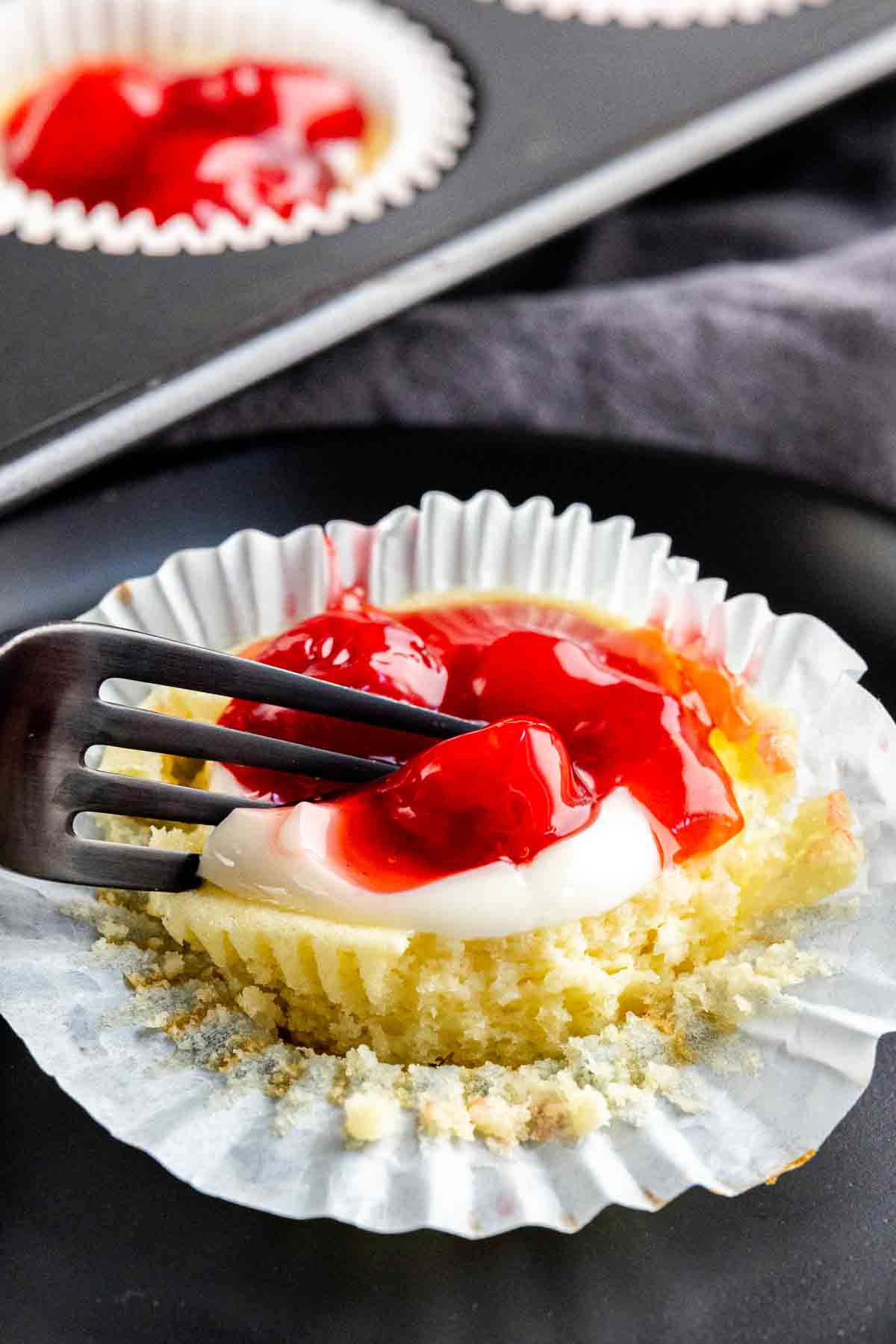 A fork is being used to eat a mini cheesecake
