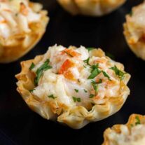 A tray of mini crab puffs with cheese and herbs.