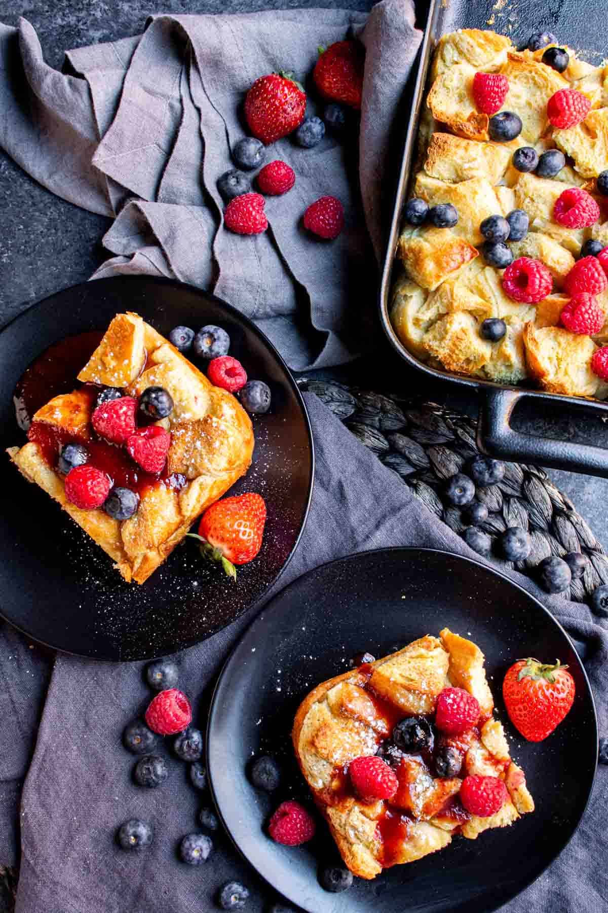 A plate of Overnight French Toast Bake with berries and raspberries.