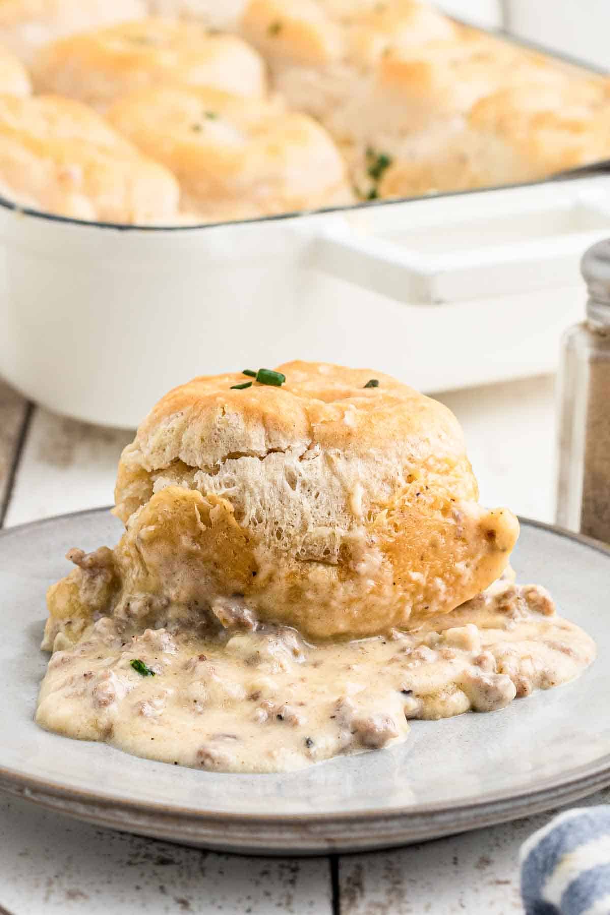 A plate with biscuits and gravy casserole on it.
