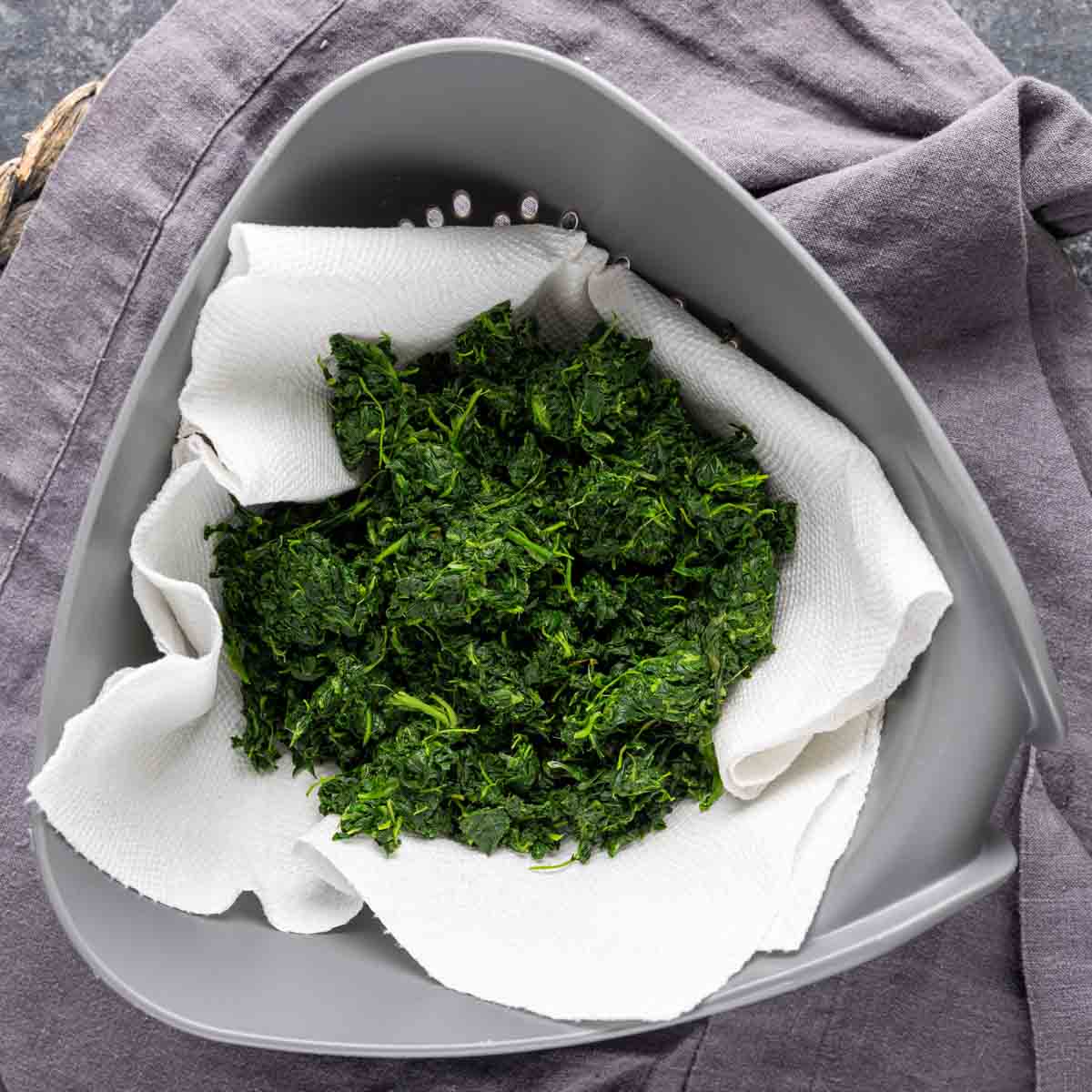 spinach strainer on a grey cloth for Spinach Puffs