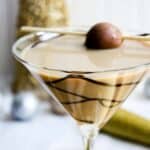 A chocolate martini in a martini glass with chocolate.