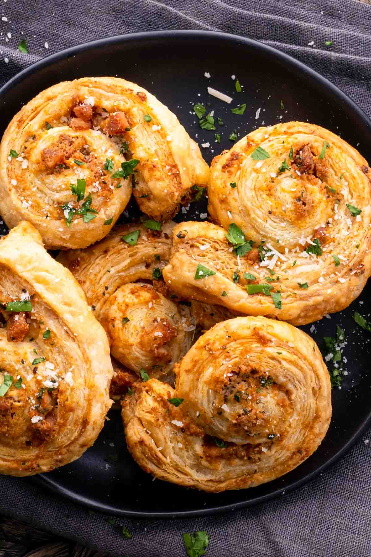 A plate of stuffed pastry with parmesan cheese and parsley.