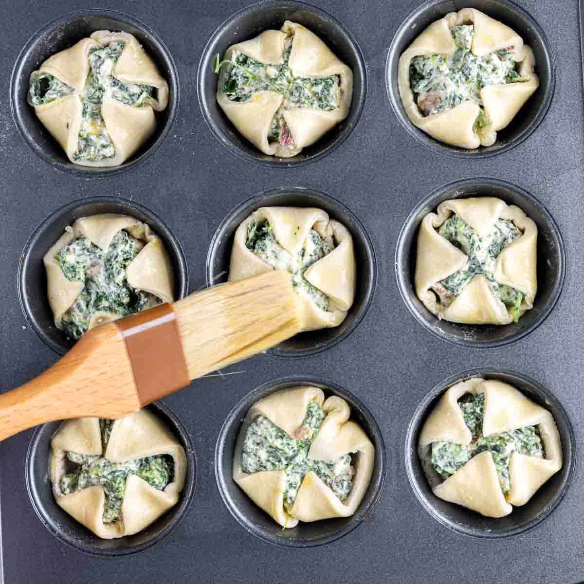 A pan full of Spinach Puffs in a muffin tin.