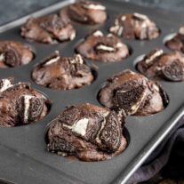 Chocolate oreo muffins in a muffin tin.