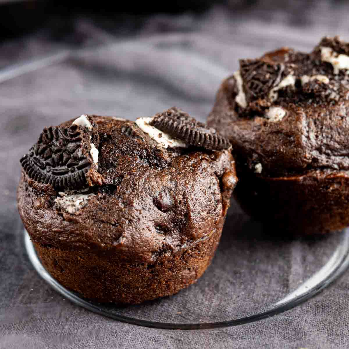 Chocolate oreo muffins on a glass plate.