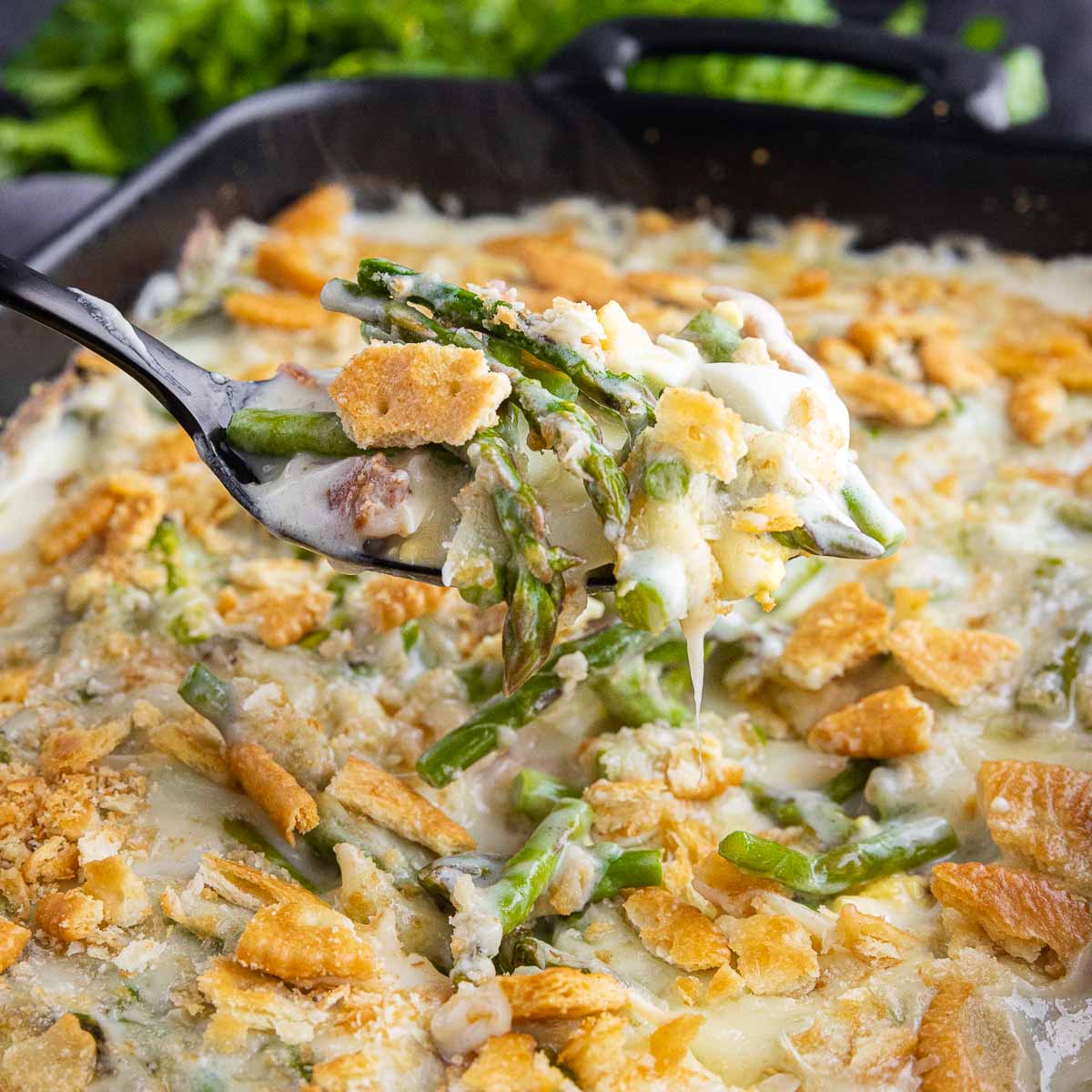 A spoonful of asparagus casserole casserole in a skillet.