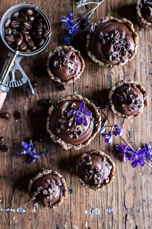 Chocolate and coffee tarts on a wooden table.
