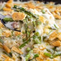 A spoonful of asparagus and cheese casserole in a skillet.