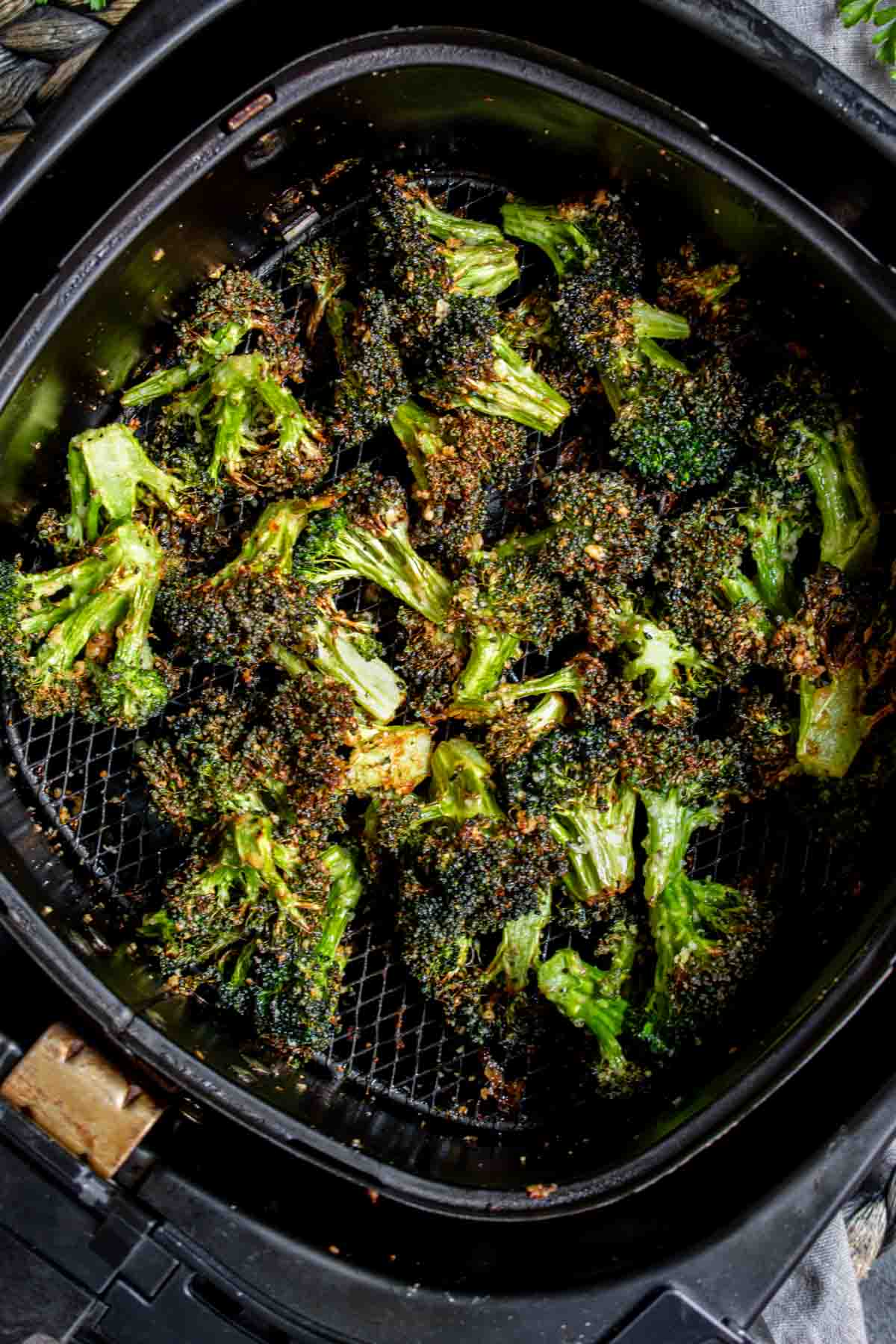 Air Fryer Broccoli florets in an air fryer basket.