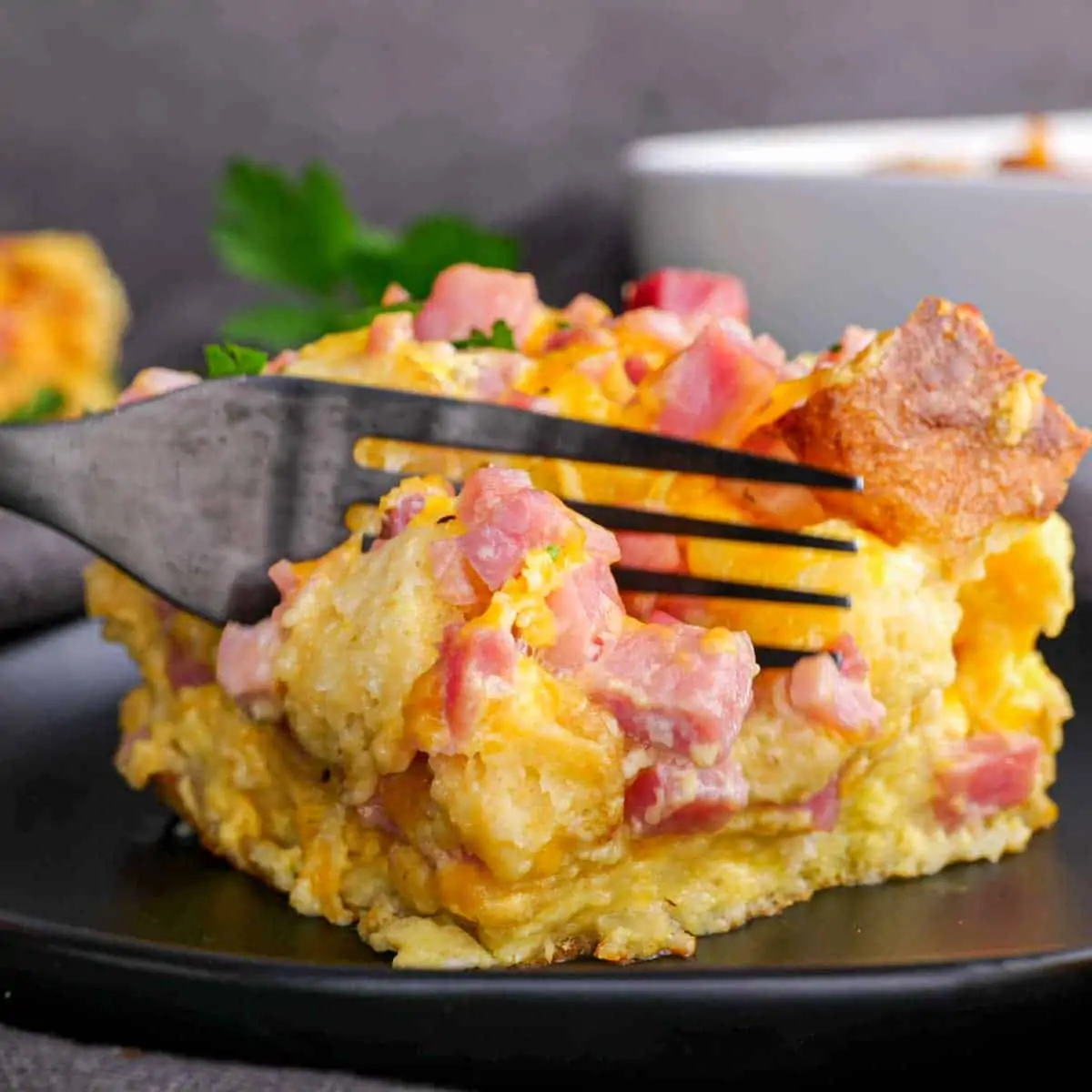 Ham and Cheese English Muffin Breakfast Casserole on a plate with a fork.