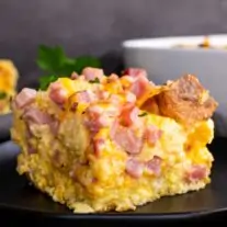 A plate of Ham and Cheese English Muffin Breakfast Casserole-11 on a table.